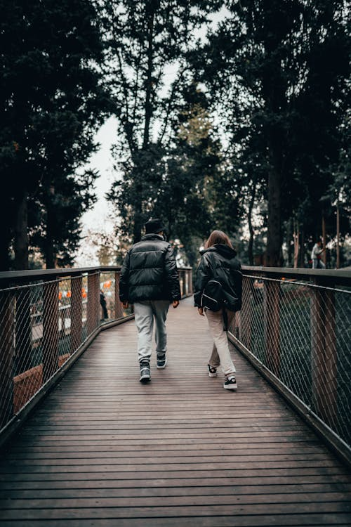 Two people walking on a bridge